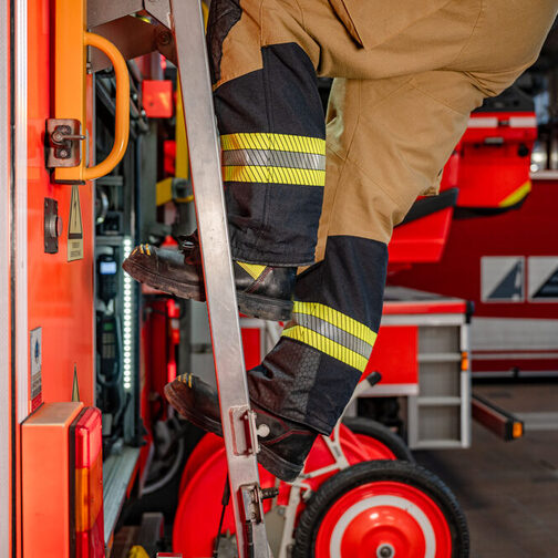 Feuerwehrmann klettert eine Leiter hoch.