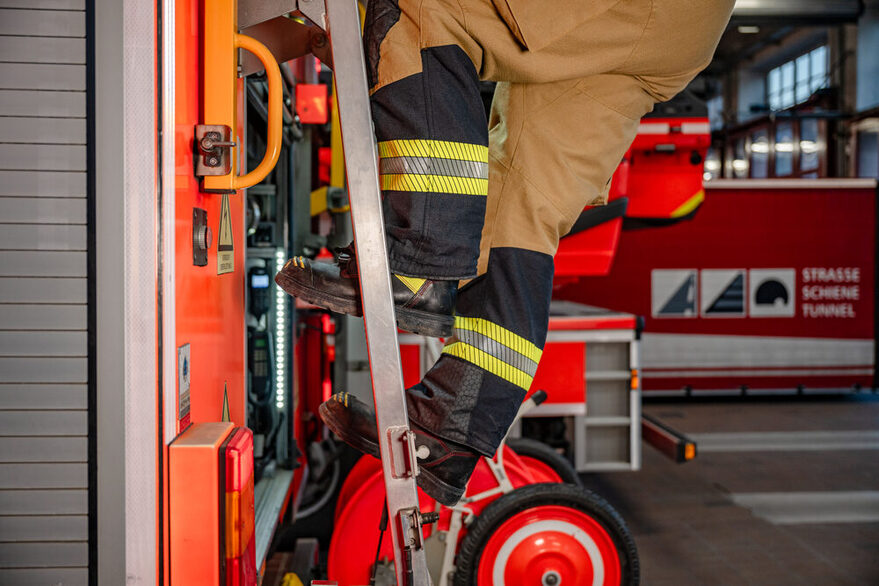 Feuerwehrmann klettert eine Leiter hoch.