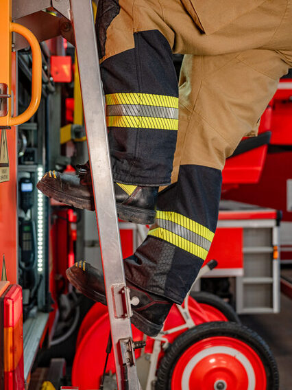 Feuerwehrmann klettert eine Leiter hoch.